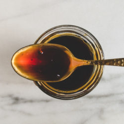 Taiwanese thick soy sauce in a glass jar with a spoon on top.