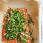 mayo ketchup baked salmon with fresh herbs on top.