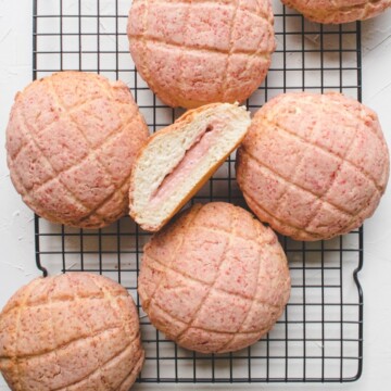 strawberry pineapple buns with cream cheese filling on a cooling rack.