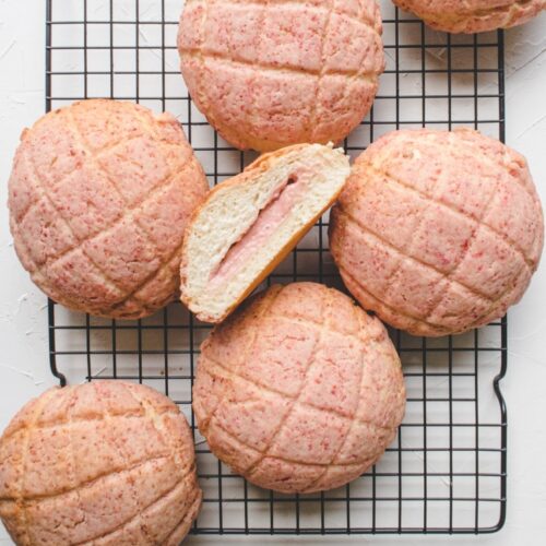 strawberry pineapple buns with cream cheese filling on a cooling rack.