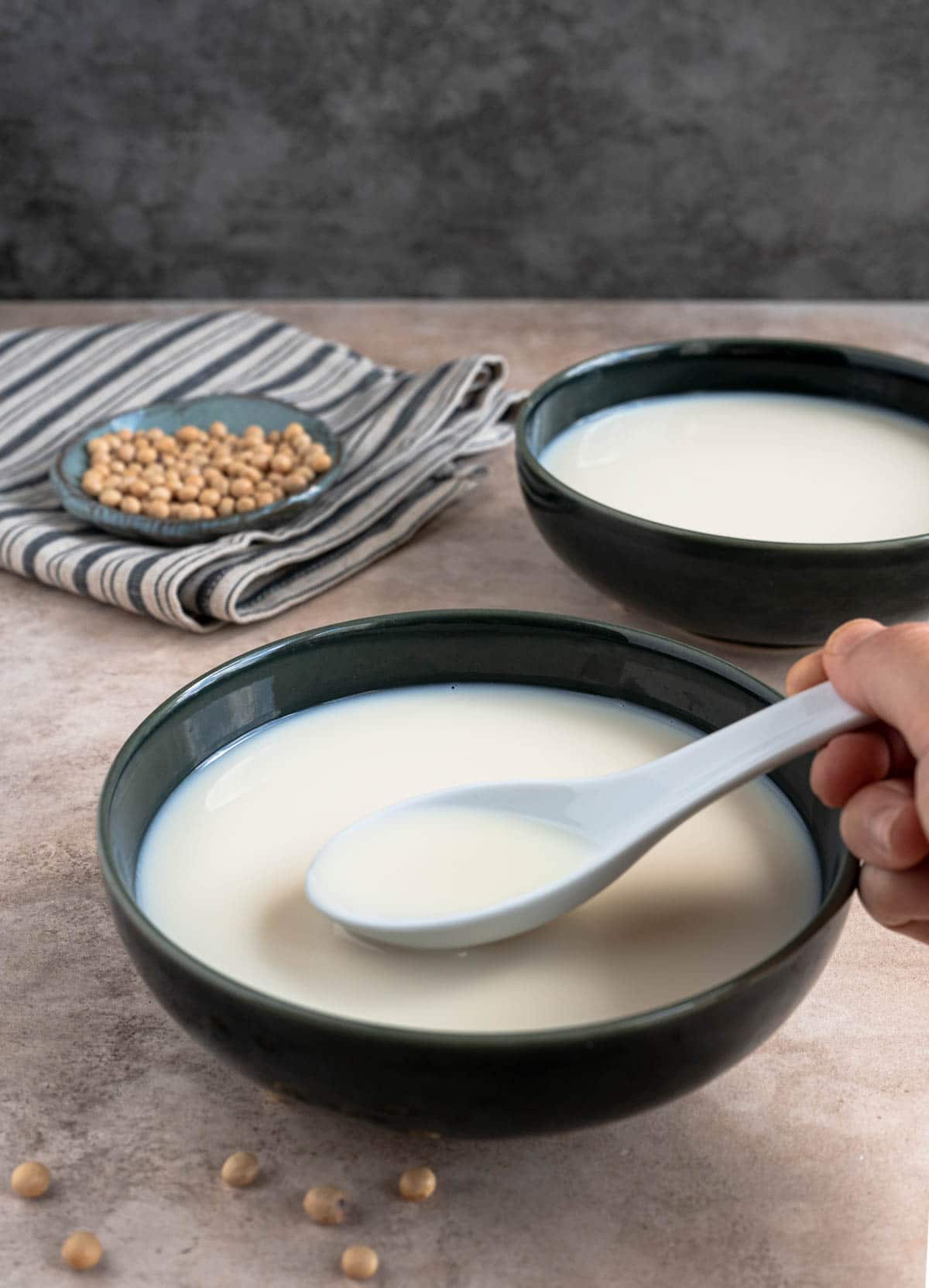 Scoop up soy milk with a white spoon.