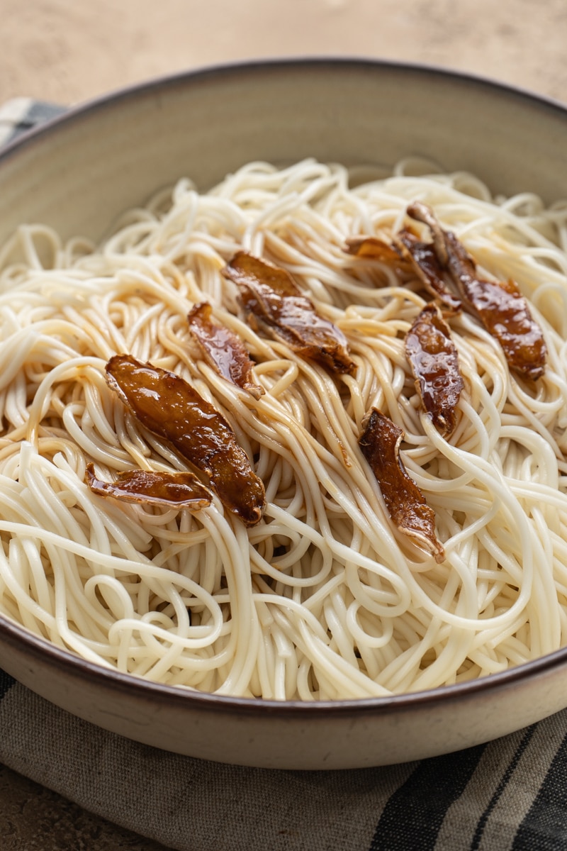 A bowl of noodle drizzled with ginger soy dressing.